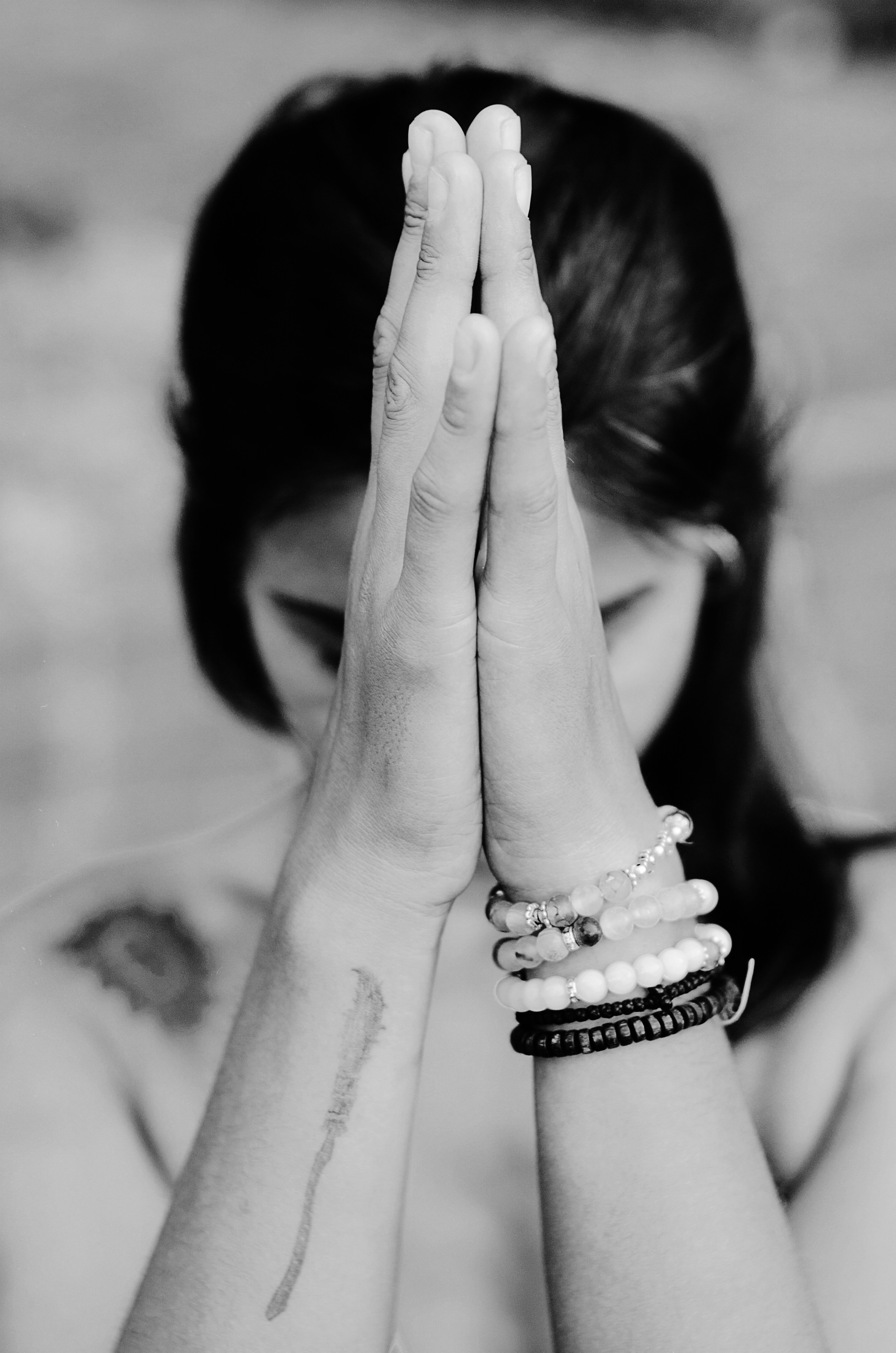 person with hands in prayer position in front of their face